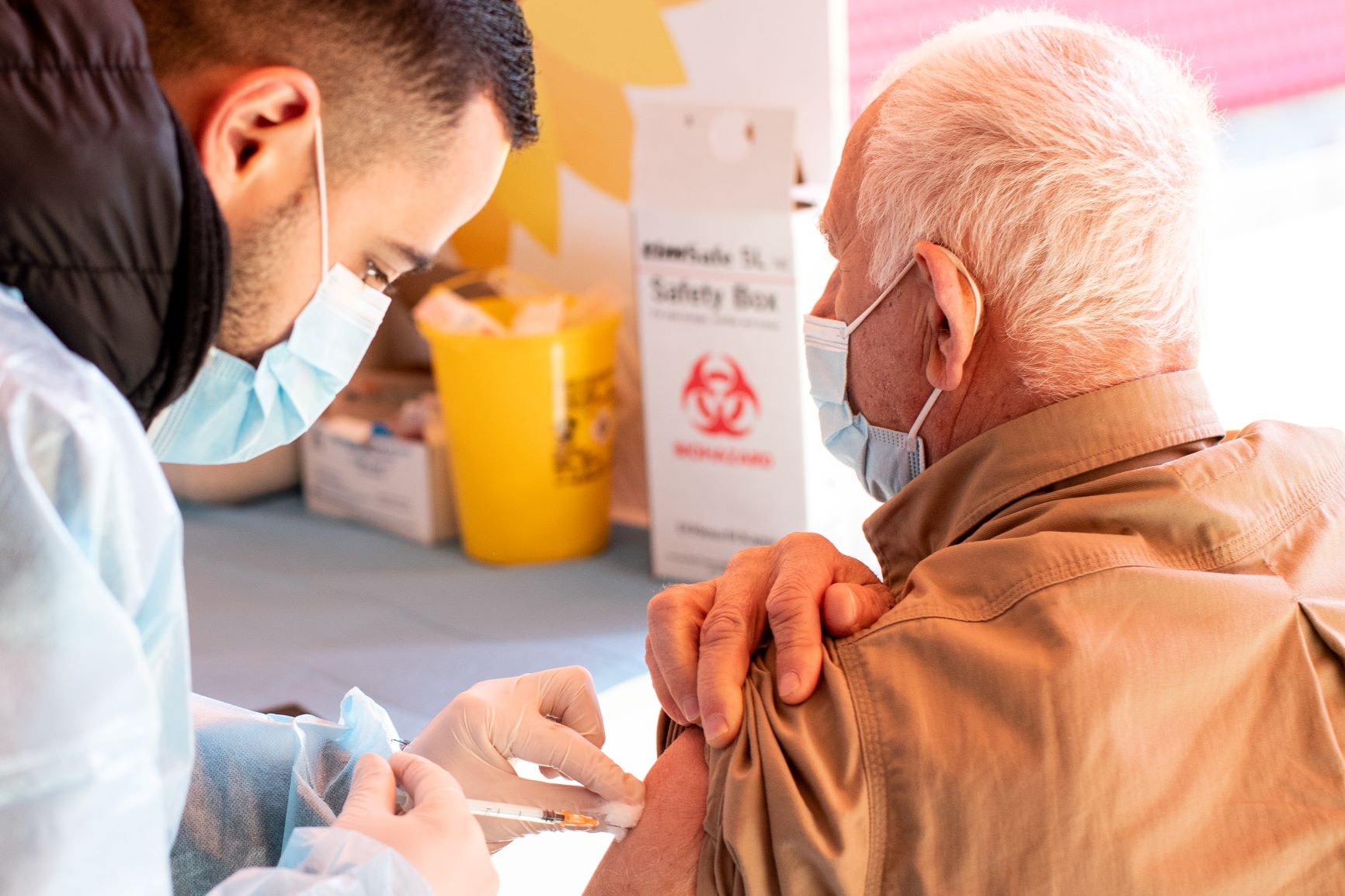 Man receiving vaccine in the arm from a health worker