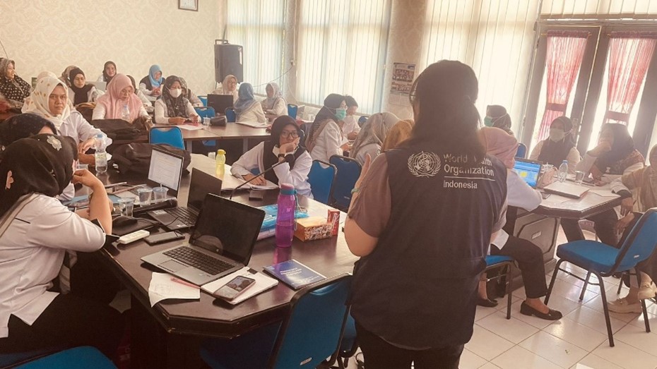 WHO Vaccination Technical Officer in front of a class of health care workers